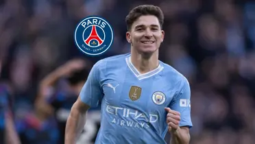 Julian Alvarez smiles while wearing the Manchester City jersey and the PSG badge is next to him. (Mega PSG X)