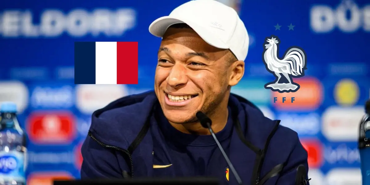 Kylian Mbappé smiles while he talks in a press conference as the French flag and the French national team badge is next to him. (Source: KM 10 Zone)