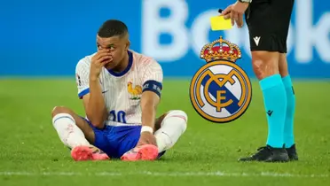 Kylian Mbappé touches his broken nose while on the ground and the Real Madrid badge is next to him. (Source: Sky Sports)