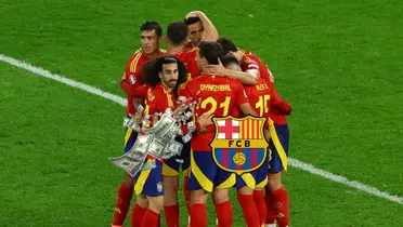 The Spanish national team players hug each other after a goal went in as the FC Barcelona badge is next to flying money. (Source: REUTERS)