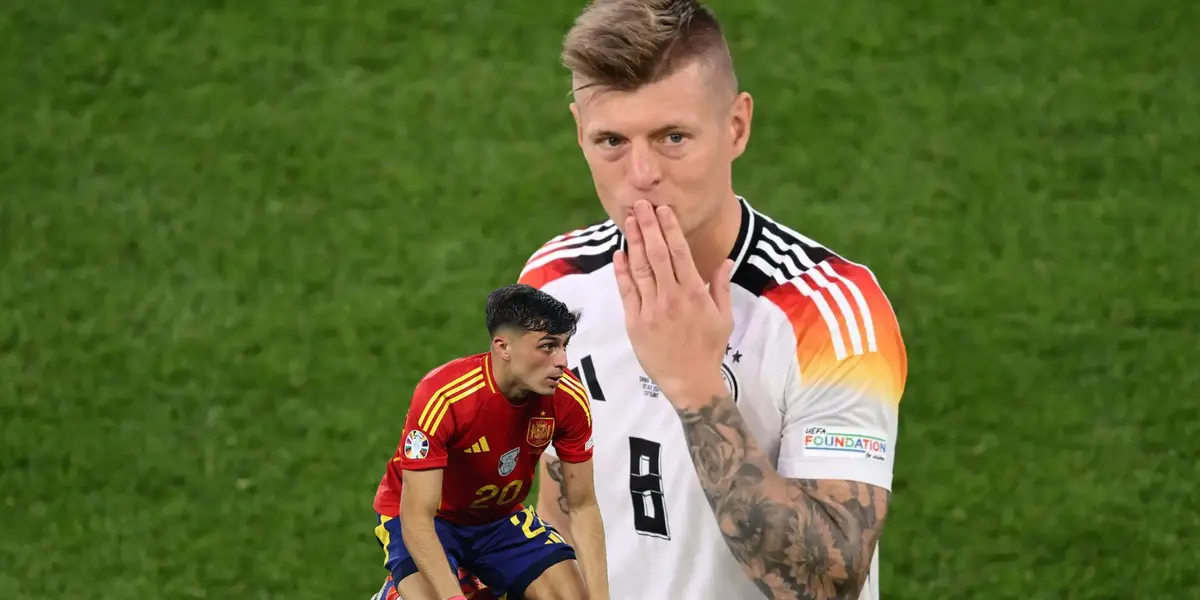 Toni Kroos blows a kiss the the crowd with a Germany jersey on while Pedri is on the ground with a Spain jersey on. (Source: Getty Images)